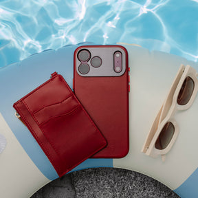 Woman holding an iPhone in the SANDMARC Pro Leather Case in red against their black leather jacket, showing the full-grain leather texture and aluminum camera mount