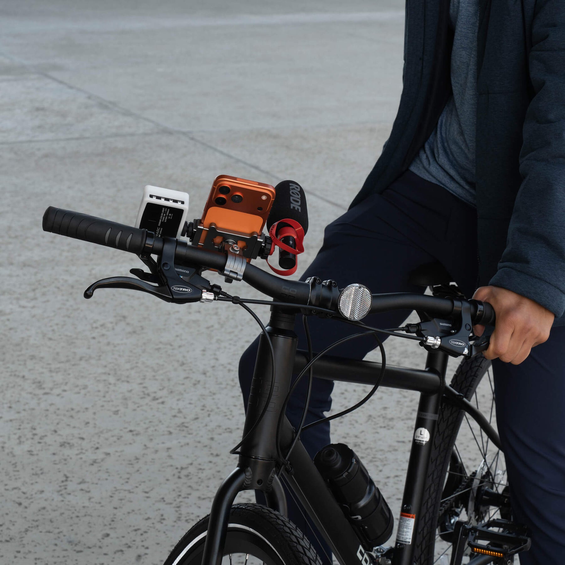 Orange iPhone on bicycle handlebars with SANDMARC Creator Bike Mount