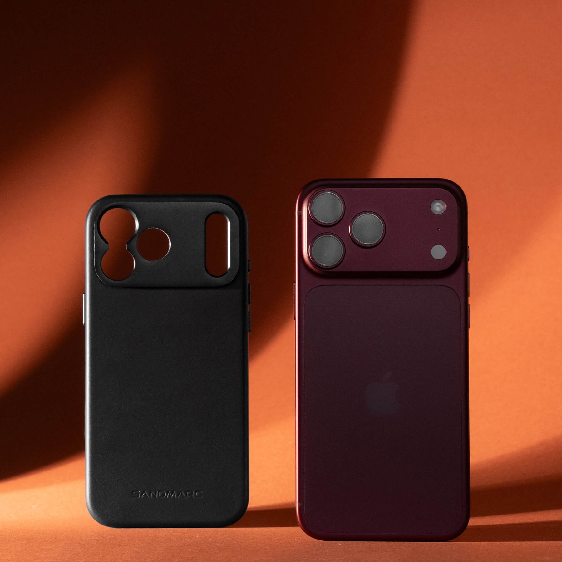 SANDMARC Pro Leather Case for iPhone 18 Pro in Black, shown next to a burgundy iPhone, on an orange background.