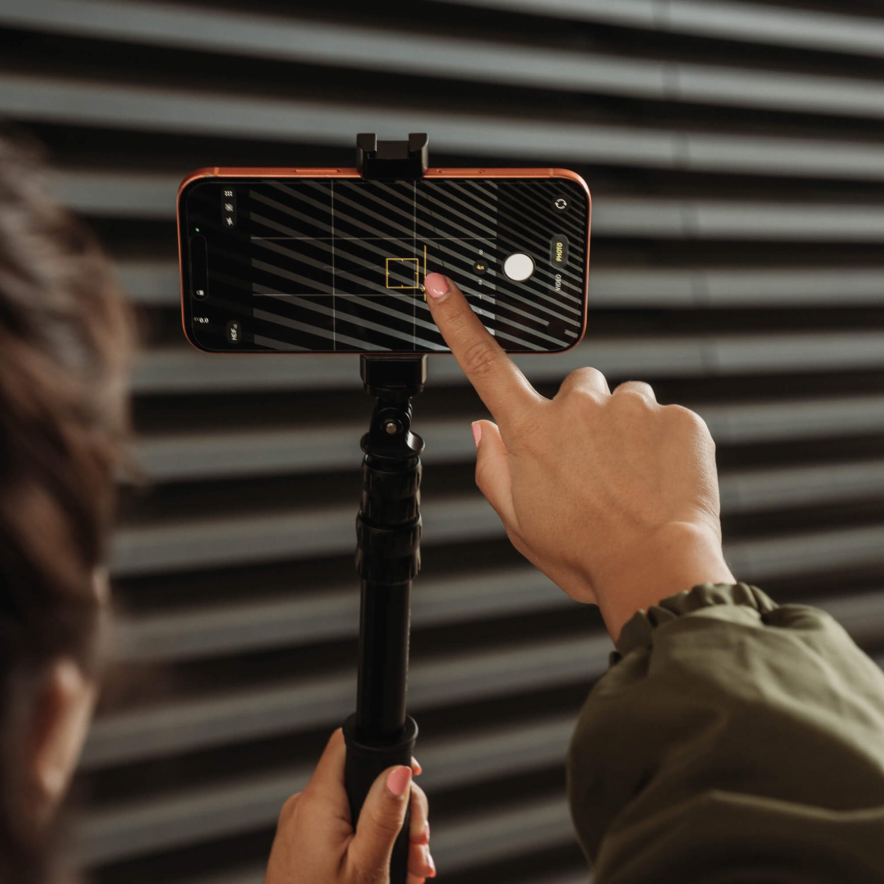 Photographer taking a photo on iPhone 17 Pro Max attached to SANDMARC Pole 