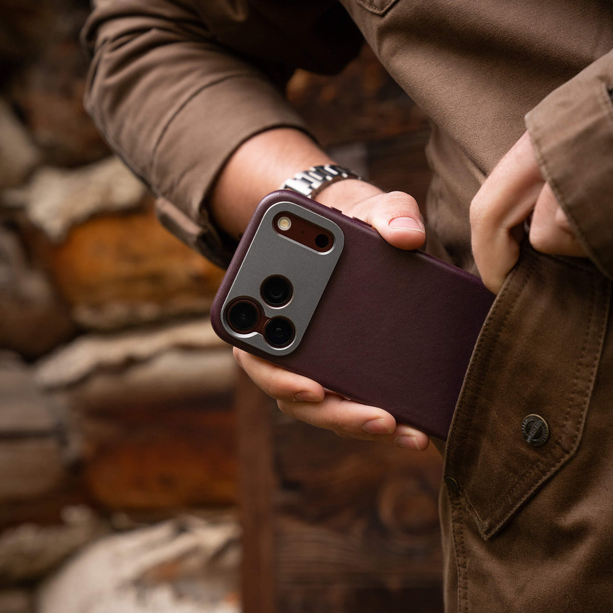 Person pulling SANDMARC Pro Leather Case for iPhone 18 Pro in Burgundy out of pocket