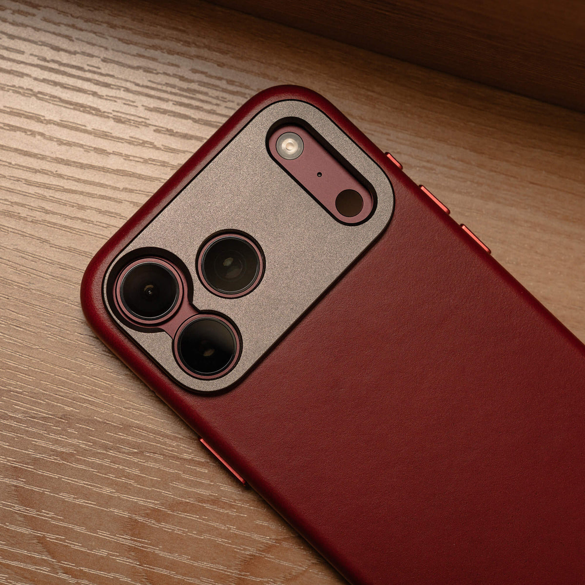 SANDMARC Pro Leather Case for iPhone 18 Pro series in Red, close-up of the camera cutout on a wooden surface