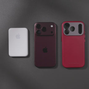 Woman holding an iPhone in the SANDMARC Pro Leather Case in red against their black leather jacket, showing the full-grain leather texture and aluminum camera mount